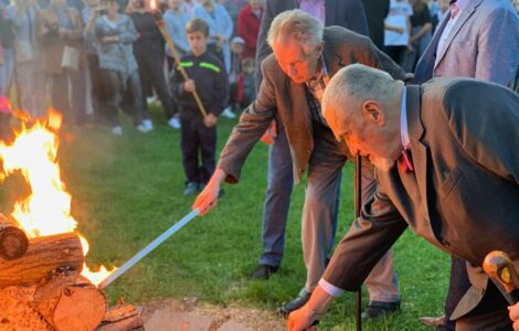 Miloš Zeman zapaluje. Hlídají ho při tom dva jeho strážci. 