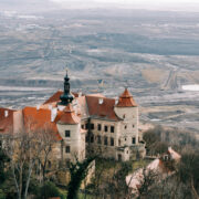 Zámek Jezeří v Krušných horách, v pozadí hnědouhelný důl Československé armády na Mostecku