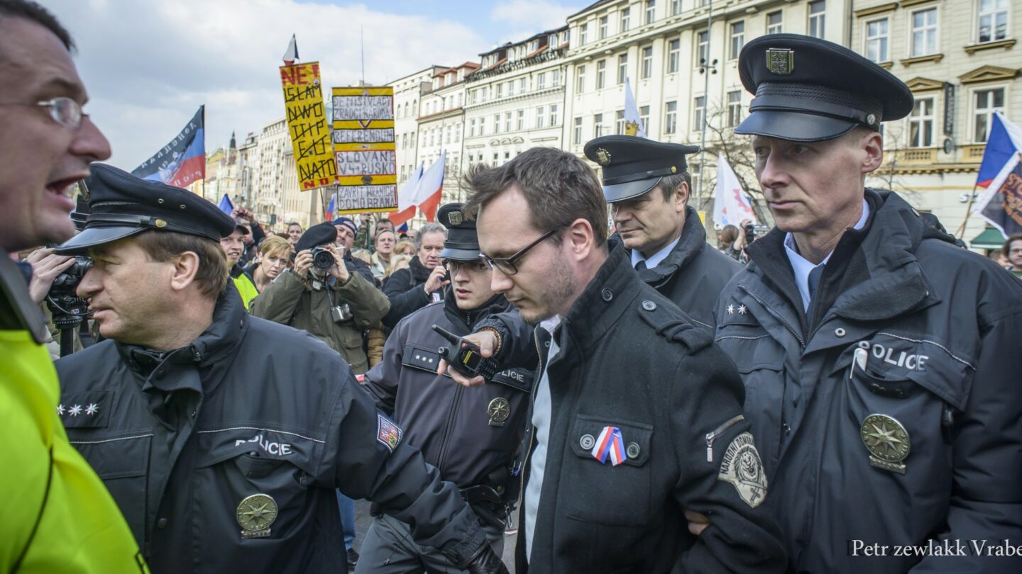 Bartoše odvádí police přímo z pódia