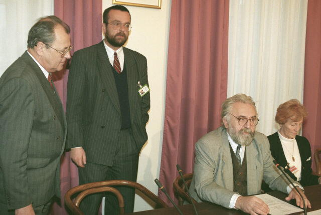 Miroslav Kalousek (stojící) jako náměstek ministra obrany v roce 1995. Zcela vlevo tehdejší ministr obrany Vilém Holáň, vpravo sedí předseda sněmovního branného a bezpečnostního výboru Vladimír Šuman.