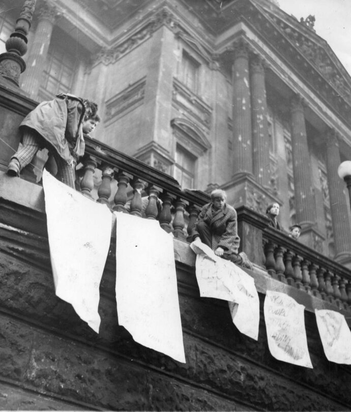 Demonstranti věší plakáty před budovu Národního muzea v Praze.